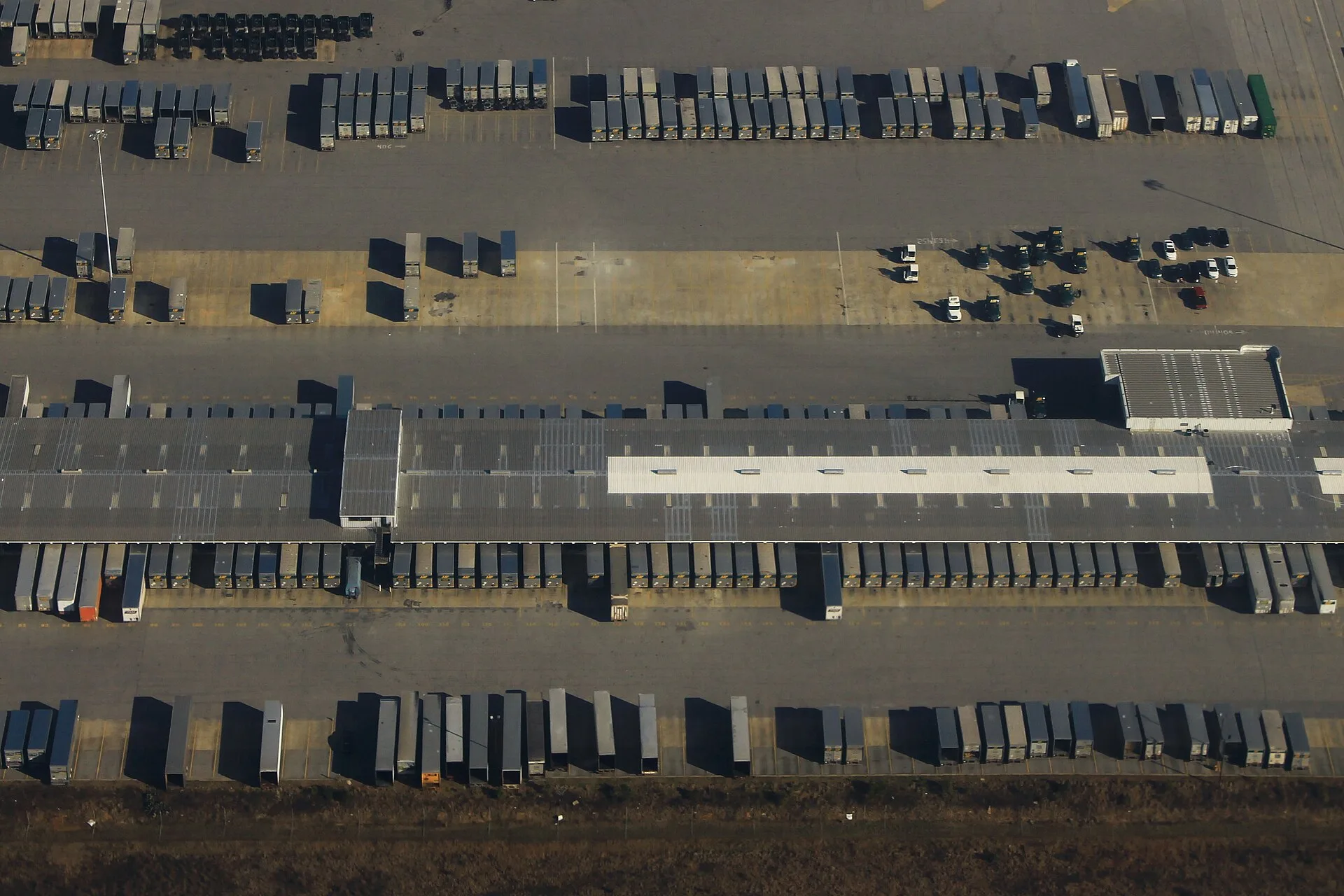 Aerial view of an LTL freight terminal with rows of trailers parked at dock doors