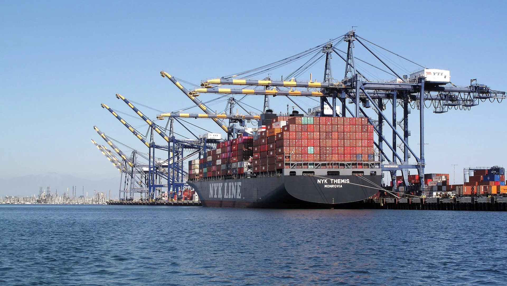 Container ship NYK Themis under ship-to-shore cranes at a Port of Los Angeles terminal