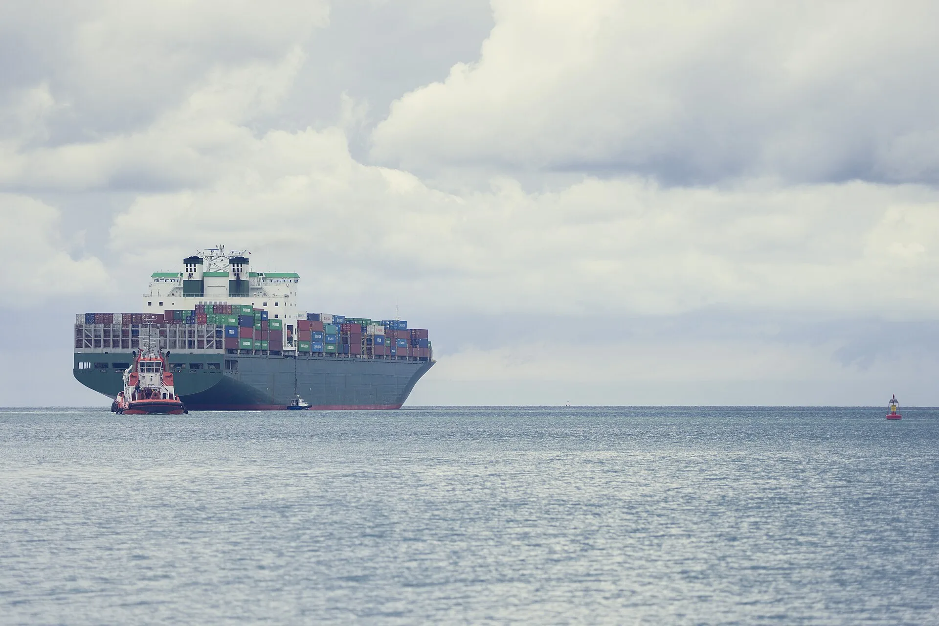 Evergreen container ship Ever Uberty loaded with containers, attended by a tug off the port of Koper