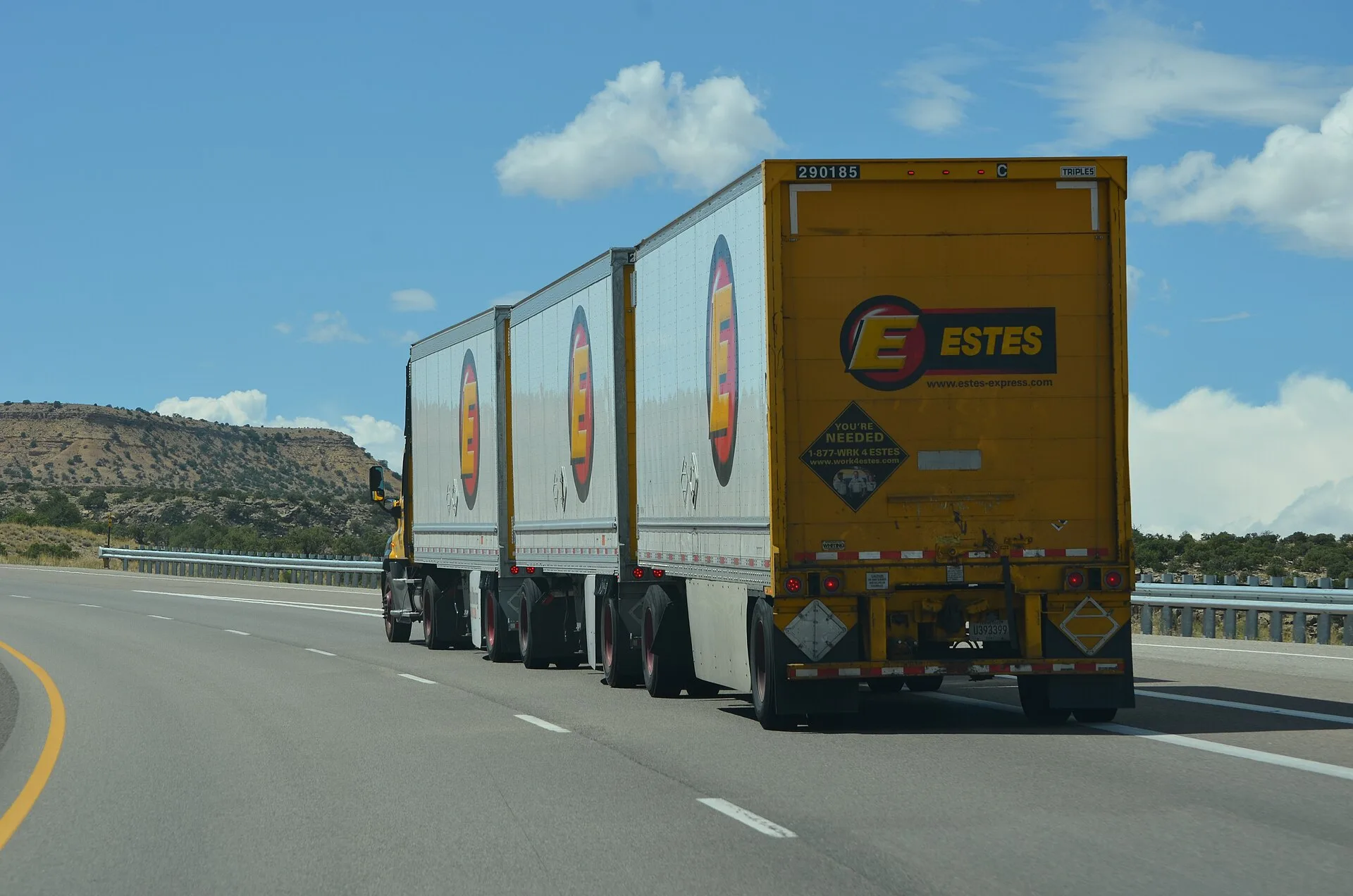 Estes Express Lines truck pulling three LTL trailers on a highway in Utah