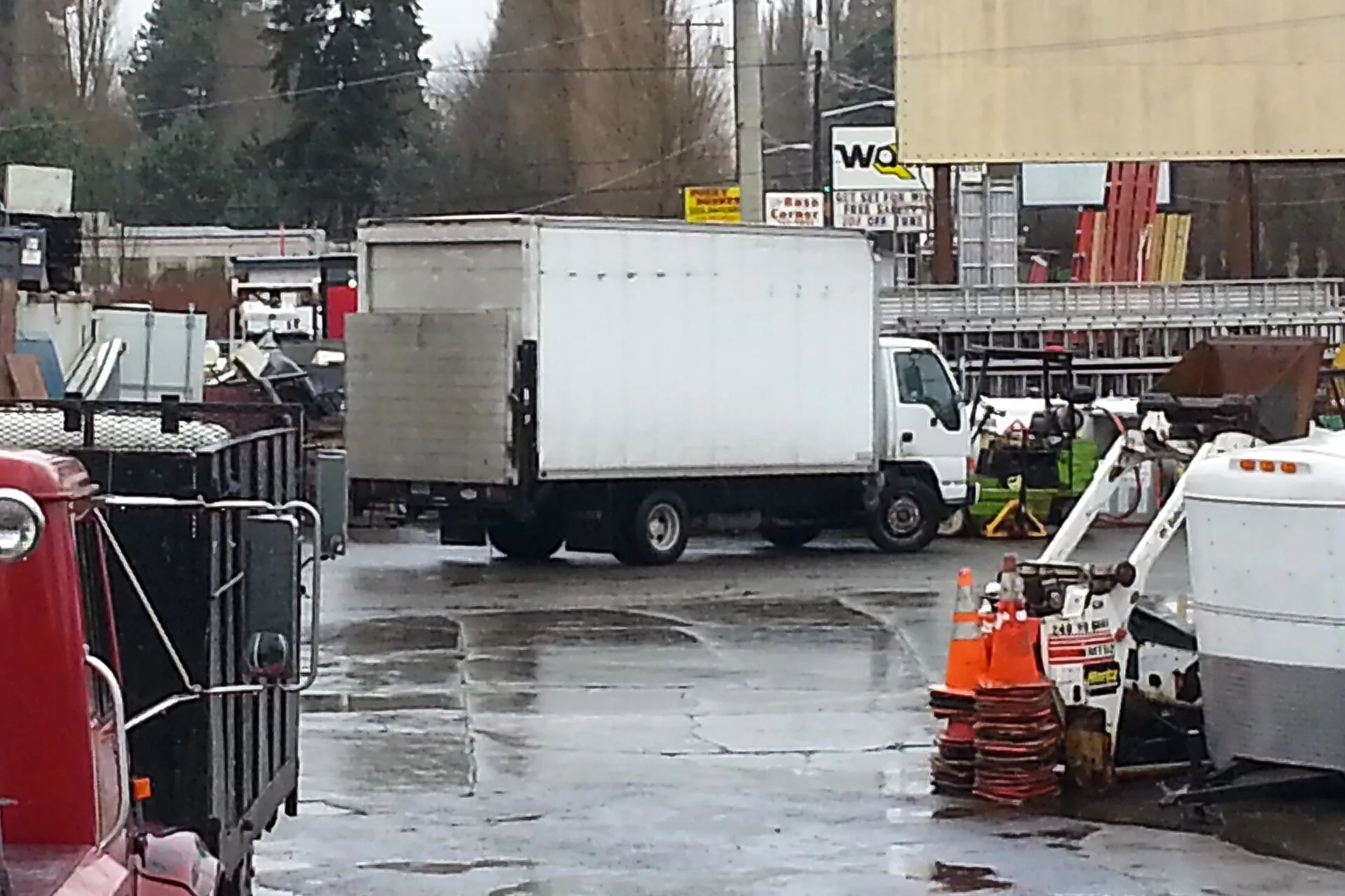 White box truck with a rail liftgate parked in a yard