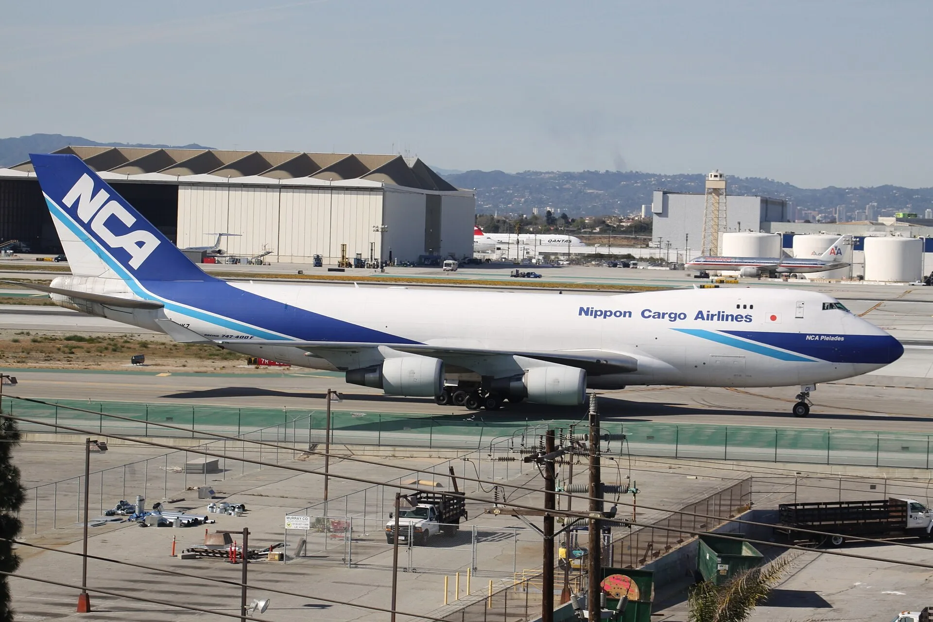 Boeing 747 freighter taxiing past cargo hangars at Los Angeles International Airport