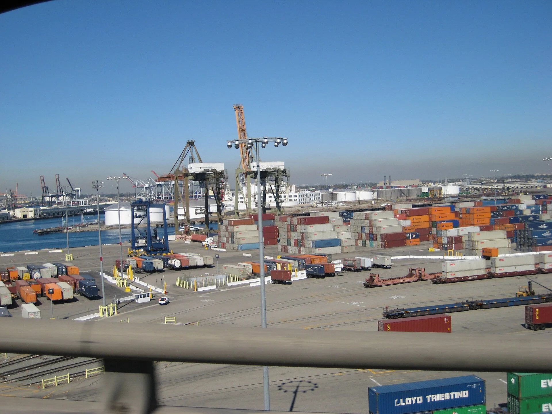 Stacked shipping containers and cranes in a container yard at the Port of Long Beach