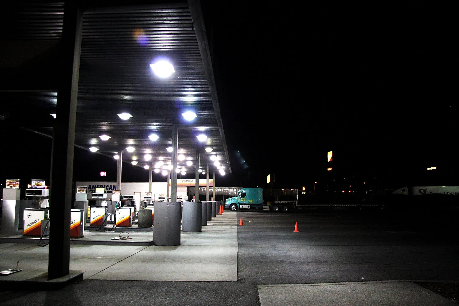 Diesel fuel pumps under the canopy of a truck stop at night